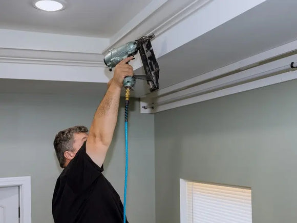 Man installing crown molding in his home in East Brookfield, MA.
