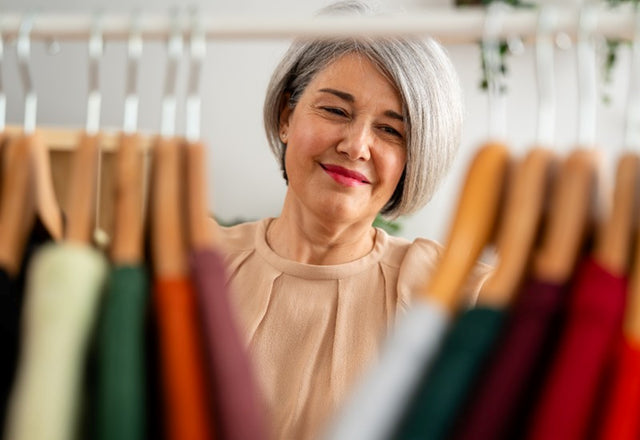 Woman sorting through clothes in her closet in MA.